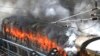 Flames rise from a train set on fire by protesters at Secundrabad railroad station in Hyderabad, India, June 17, 2022. 