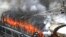 Flames rise from a train set on fire by protesters at Secundrabad railroad station in Hyderabad, India, June 17, 2022. 