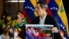 El líder opositor de Venezuela, Juan Guaidó, sostiene un cartel con una imagen, como prueba de una agresión a su persona el 11 de junio por parte de presuntos miembros del Partido Socialista Unido de Venezuela (PSUV), en Caracas, el 14 de junio, 2022.