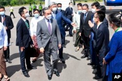 Menteri Luar Negeri China Wang Yi, tengah, disambut oleh perwakilan Kementerian Luar Negeri Myanmar dan pejabat Kedutaan China setibanya di Bandara Nyaung Oo di Bagan, Myanmar, Sabtu 2 Juli 2022. (Foto: via AP)