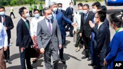 Chinese Foreign Minister Wang Yi, center, is welcomed by Myanmar Foreign Ministry representatives and Chinese embassy officials upon his arrival at Nyaung Oo Airport in Bagan, Myanmar Saturday July 2, 2022. (Myanmar Ministry of Information via AP)