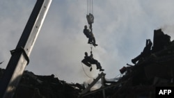 Los rescatistas ucranianos trabajan fuera de un edificio residencial dañado alcanzado por misiles rusos en Kyiv el 26 de junio de 2022, en medio de la invasión rusa de Ucrania.