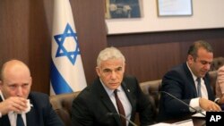 ইসরায়েলি তত্ত্বাবধায়ক প্রধানমন্ত্রী ইয়াইর লাপিদ (মাঝে), সাবেক প্রধানমন্ত্রী নাফতালি বেনেটের পাশে বসে মন্ত্রিসভার বৈঠকের সভাপতিত্ব করছেন, ৩ জুলাই, ২০২২।