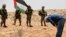 Israeli soldiers stand guard as a Palestinian man prays during a protest after the Israeli top court paved way for razing eight Palestinian hamlets, in Masafer Yatta, south of Hebron, in the Israeli-occupied West Bank, June 17, 2022.