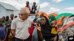 Norwegian Refugee Council's Secretary General Jan Egeland (L), meets a displaced mother of seven children who fled drought but whose husband had to stay back home to look after their farm and elderly parents, in Qaydar-ade camp for IDPs in Baidoa, Somalia, June 21, 2022.