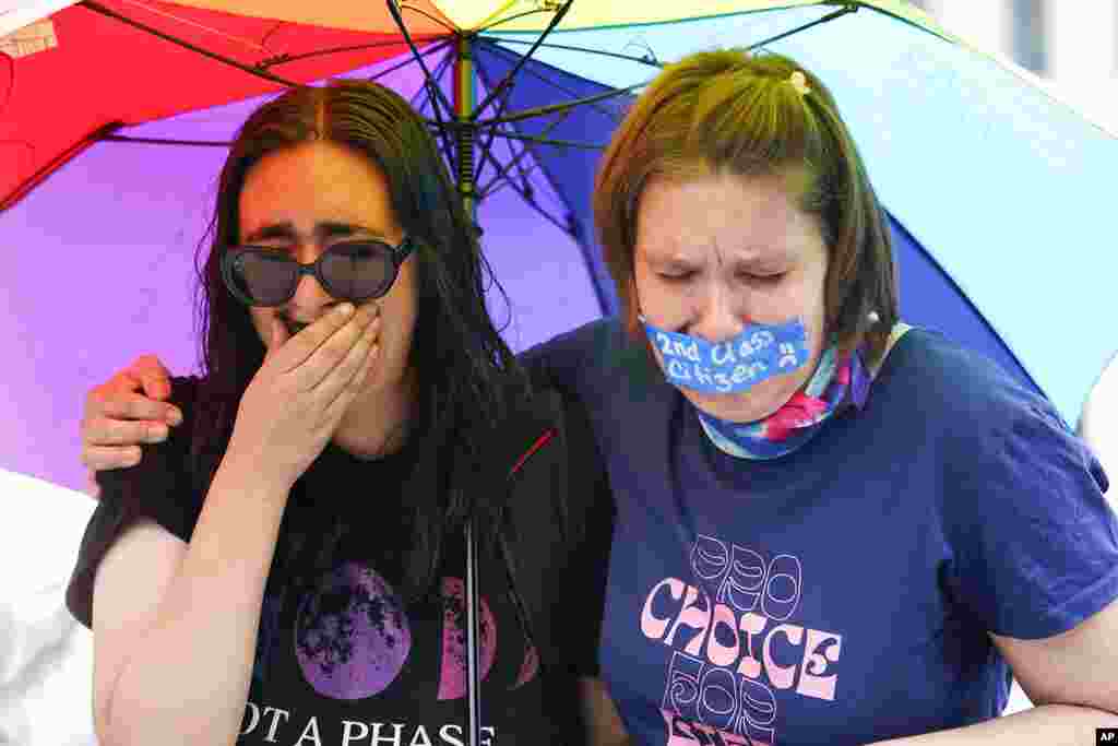 Abortion-rights activists react after hearing the Supreme Court decision on abortion outside the Supreme Court.
