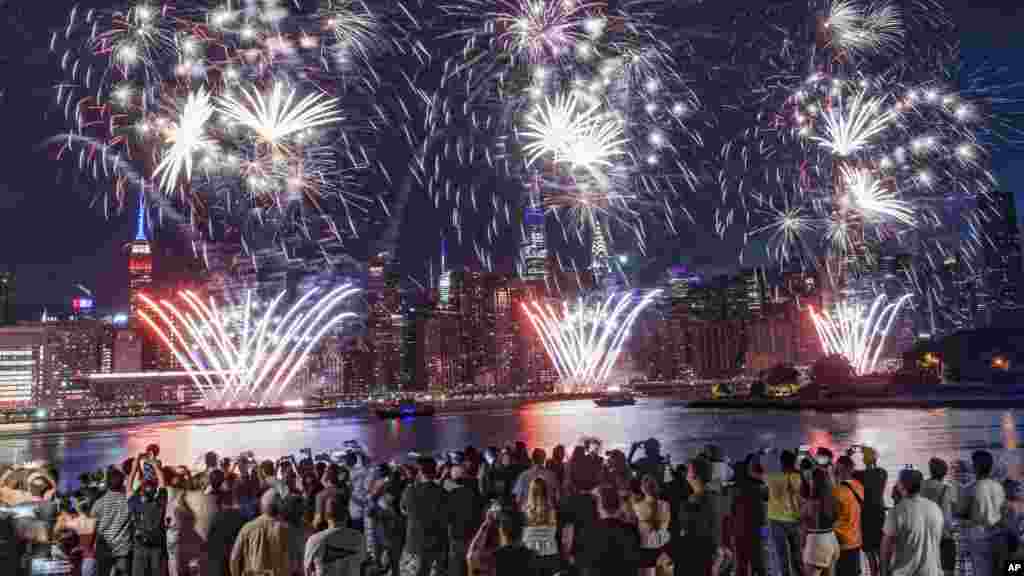 Spectators gather along Williamsburg&#39;s waterfront, in the New York borough of Brooklyn, for the Macy&#39;s fireworks display as fireworks explode from barges on the East River to celebrate Independence Day, in New York, July 4, 2022.