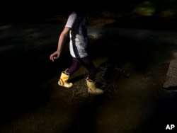 A child splashes in a puddle to beat the summer heat in Doraville, Ga. in this Wednesday, June, 15, 2022 iPhone photo, taken by Brynn Anderson. (AP Photo/Brynn Anderson)