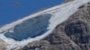 A rescue helicopter hovers over the Punta Rocca glacier near Canazei, in the Italian Alps in northern Italy, July 4, 2022, a day after a huge chunk of the glacier broke loose, sending an avalanche of ice, snow, and rocks onto hikers.