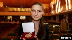 Penerima Medali Fields untuk Matematika Maryna Viazovska berpose dengan medalinya dalam upacara pemberian hadiah di Kongres Internasional Matematikawan 2022 (ICM 2022) di Helsinki, 5 Juli 2022. (Vesa Moilanen/Lehtikuva via Reuters)