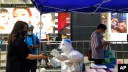 Residents line up for COVID-19 testing, July 6, 2022, in Shanghai. Residents of parts of Shanghai and Beijing have been ordered to undergo further rounds of COVID-19 testing following the discovery of new cases in the two cities.