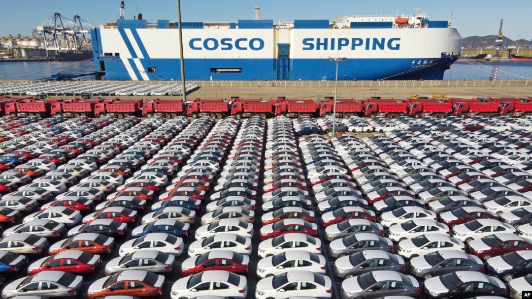 FILE - In this photo released by Xinhua News Agency, an aerial view shows manufactured vehicles before being loaded onto a cargo ship at the Yantai Port in eastern China's Shandong Province, Dec. 7, 2021.