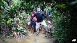 FILE - British journalist Dom Phillips, right, and a Yanomami Indigenous man walk in Maloca Papiu village, Roraima state, Brazil, Nov. 2019.