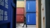 一名俄罗斯海关官员走过加里宁格勒港口堆积的中国集装箱货柜。（2021年10月28日）