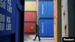 一名俄罗斯海关官员走过加里宁格勒港口堆积的中国集装箱货柜。（2021年10月28日）