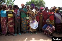 FILE - Women stand in line for food aid distribution delivered by the United Nations Office for the Coordination of Humanitarian Affairs and world food program in the village of Makunzi Wali, Central African Republic, April 27, 2017.