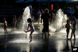 ILLUSTRATION - Children playing in a fountain enjoying the end of a hot day at VDNKh (Exhibition of Achievements of the National Economy) Moscow, Russia, Monday, June 27, 2022. (AP/Alexander Zemlianichenko)