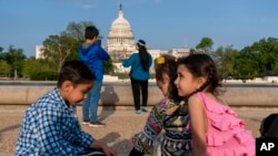 Porodica Safi slavi Bajram fotografirajući porodične fotografije u National Mall-u, u utorak, 3. maja 2022., u blizini američkog Kapitola u Washingtonu. Porodica je evakuisana iz Afganistana i pokušava da napravi novi život u SAD, dok je u imigracionom limbu. (AP Photo/Jacquelyn Martin)