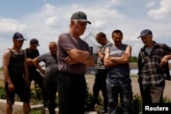 Wheat farmers talk to Reuters in a wheat farm outside Bashtanka, Mykolaiv region, as Russia's attacks on Ukraine continue, Ukraine June 9, 2022.