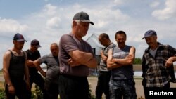 Українські сільськогосподарські працівники поблизу Баштанки у Миколаївській області 9 червня 2022 р.