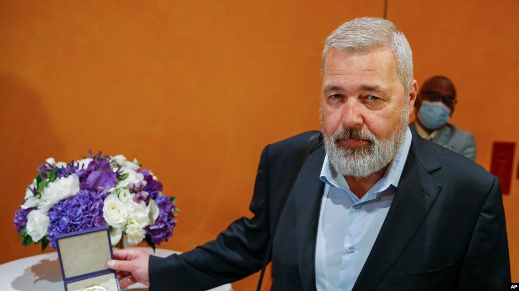 Nobel Peace Prize winner Dmitry Muratov, editor-in-chief of the influential Russian newspaper Novaya Gazeta, poses for a picture next to his 23-karat gold medal before it is auctioned at the Times Center, June 20, 2022, in New York.