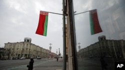 FILE: A Belarusian national flag flutters over a street in Minsk, Belarus, Feb. 16, 2022.
