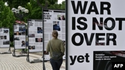 A woman visits the photo exhibition 'The war is not over' opened in the Taras Shevchenko park in Kyiv on June 23, 2022.