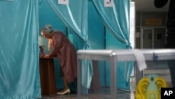 FILE - A woman fills in her ballot at a polling station during the nationwide referendum in Nur-Sultan, Kazakhstan, June 5, 2022. Kazakhs voted on a package of reforms intended to transform the country from a super-presidential system to a "presidential system with a strong parliament." (Vladimir Tretyakov/NUR.KZ via AP)