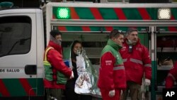 Para petugas tanggap darurat merawat seorang perempuan yang berhasil diselamatkan dari kebakaran di sebuah apartemen di Buenos Aires, Argentina, pada 23 Juni 2022. (Foto: AP/Victor R. Caivano)