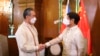 In this photo provided by the Malacanang Presidential Photographers Division, Philippine President Ferdinand Marcos Jr., right, greets Chinese Foreign Minister Wang Yi as he arrives for a courtesy call at the Malacanang Presidential Palace in Manila, Phil