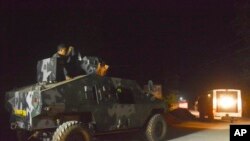 FILE - Philippine marines escort a police van believed to be carrying the body of German hostage Juergen Gustav Kantner, on Jolo island in southern Philippines, March 5, 2017.