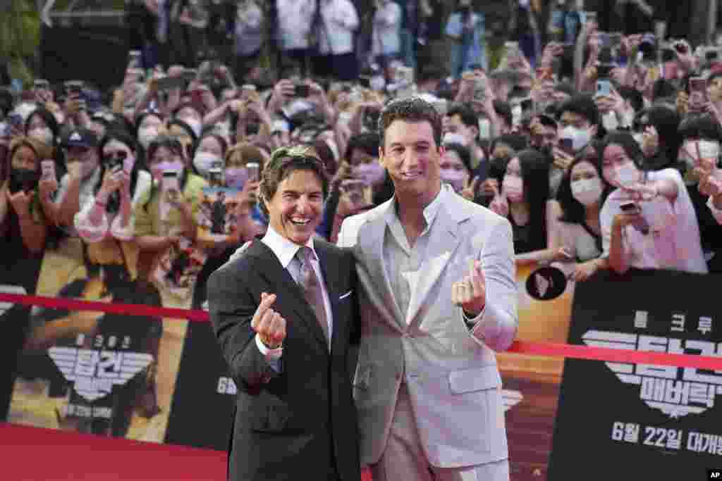 Tom Cruise, left, and Miles Teller gestures during the red carpet event to promote their latest movie Top Gun: Maverick in Seoul, South Korea.