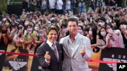 Aktor Tom Cruise (kiri) and Miles Teller berpose untuk para fotografer ketika tiba di karpet merah acara pemutaran film Top Gun: Maverick di Seoul, Korea Selatan, pada 19 Juni 2022. (Foto: AP/Lee Jin-man)