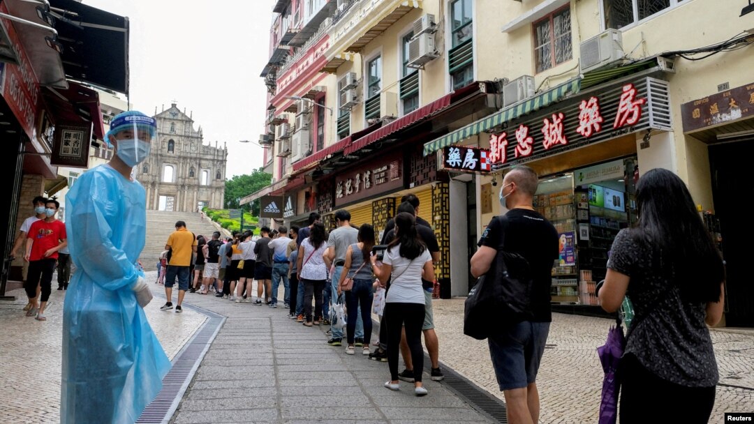 FILE - People queue for COVID-19 testing in Macau, China, June 20, 2022. Testing for all residents will take place three times this week across the city, with people also required to take rapid antigen tests in between. 