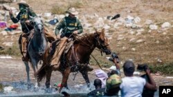 Nobedarên Sînor yên Amerîka hewil didin ku koçberan desteser bikin, dema ku ew ji Meksîko, derbaszî Texas Amerîka dibin, 19 Îlona 2021.