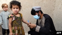 FILE - A health worker marks a child's finger with ink after giving polio vaccine at a campaign in Kandahar, Afghanistan, on June 28, 2022. 