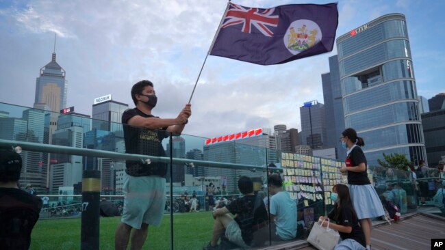 FILE - A protester waves Hong Kong British colony flag during continuing pro-democracy rallies in Tamar Park, Hong Kong, on Sept. 3, 2019. (AP Photo/Vincent Yu, File)
