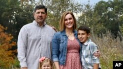 Reda Hicks appears with her husband Jake Hicks, left, daughter Katie and son Howard in Houston on Nov. 21, 2021. Reda Hicks, 41, was born and raised in Odessa, the epicenter of the West Texas oil industry. 