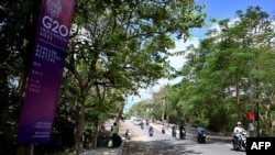Motorcyclists ride past a banner for the G-20 Foreign Ministerial Meeting scheduled to be held this July 7-8, outside the meeting venue in Nusa Dua on Indonesia's resort island of Bali on July 5, 2022.