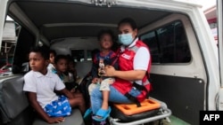 Miembros de la Defensa Civil ayudan a evacuar a los niños en el puerto de Blufields antes de la llegada de la tormenta tropical Bonnie al pueblo de Bluefields, Nicaragua, el 1 de julio de 2022.