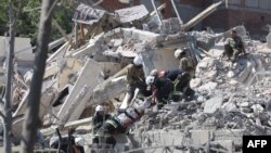 Des sauveteurs évacuent le corps d'une personne d'un bâtiment détruit après avoir été touché par une frappe de missile dans la ville ukrainienne de Sergiyvka, près d'Odessa, tuant au moins 18 personnes et en blessant 30, le 1er juillet 2022.
