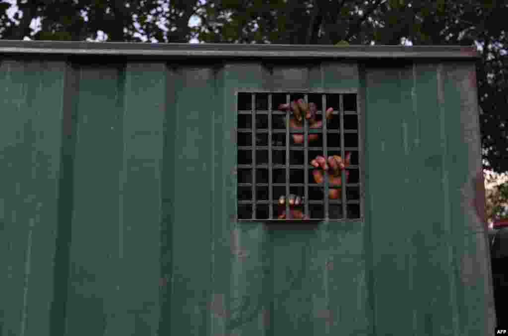 The hands of recaptured inmates are seen inside a prison vehicle in Abuja, Nigeria, after suspected Boko Haram gunmen attacked the Kuje Medium Prison.