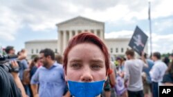 An abortion rights protester with tape reading "2nd Class Burger" demonstrates following the Supreme Court's decision to Roe v.  Wade outside the Supreme Court in Washington to reverse.