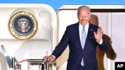 President Joe Biden waves as he leaves Air Force One after arriving at Franz-Josef-Strauss Airport near Munich, Germany, June 25, 2022, ahead of the G7 summit. 