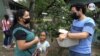 Joel García, un voluntario que presta sus servicios sanitarios en la comunidad de San Nicolás, en Honduras, le entrega una medicina a una mujer que no puede acceder a una mínima asistencia médica. 