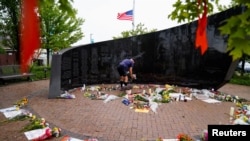 A man leaves flowers at a memorial site after a mass shooting at a Fourth of July parade in the Chicago suburb of Highland Park, Illinois, July 6, 2022.