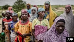 A group of woman wait for the arrival of a United Nations convoy near the village of Sabon Machi, Maradi region, Niger on Aug. 16, 2018. 