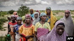 A group of woman wait for the arrival of a United Nations convoy near the village of Sabon Machi, Maradi region, Niger on Aug. 16, 2018. 