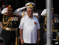 FILE- Sri Lankan President Gotabaya Rajapaksa sings the country's national anthem during Independence Day celebrations in Colombo, Feb. 4, 2022. Demonstrators have for months demanded his resignation, the last of six family members still clinging to power.