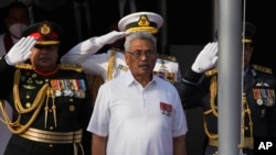 FILE- Then-Sri Lankan President Gotabaya Rajapaksa sings the country's national anthem during Independence Day celebrations in Colombo, Feb. 4, 2022. 